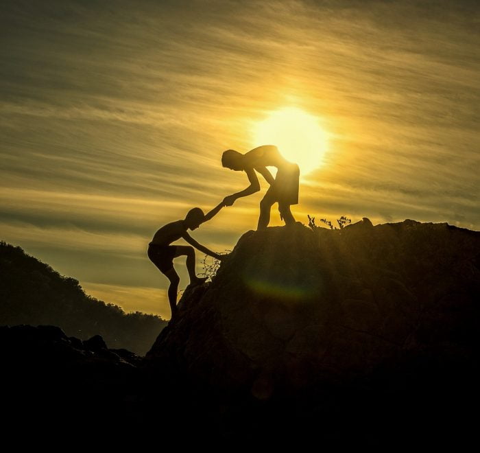 Deux amis escaladant un rocher