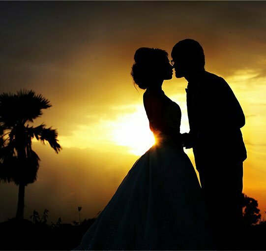 Couple s'embrassant pendant le coucher de soleil