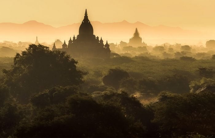 Aube sur un temple entouré d'une forêt en Birmanie