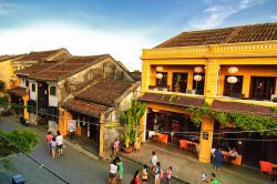 Rue colorée et passants prenant des photos à Hoi An