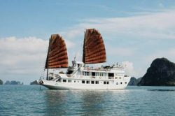Jonque blanche avec voiles marrons dans la baie d'Halong